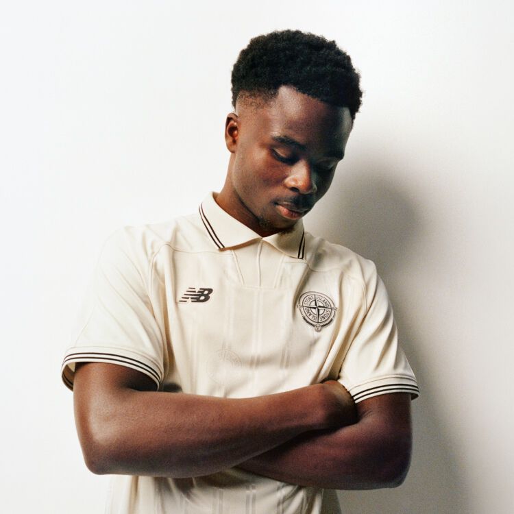 Endrick leaning against a wall wearing a green soccer uniform with his arms together 