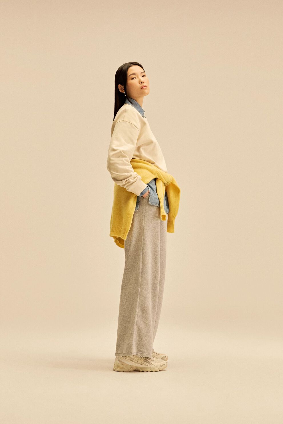 A person standing against a tan studio backdrop.