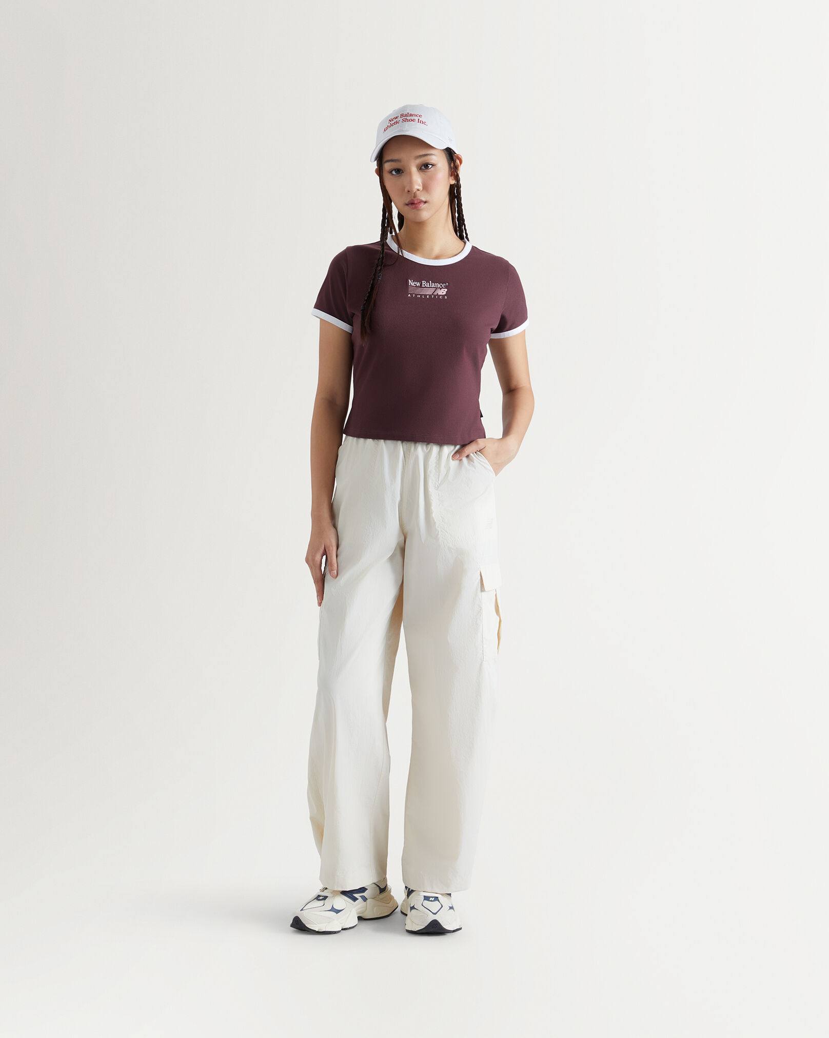 A woman standing in front a white wall.