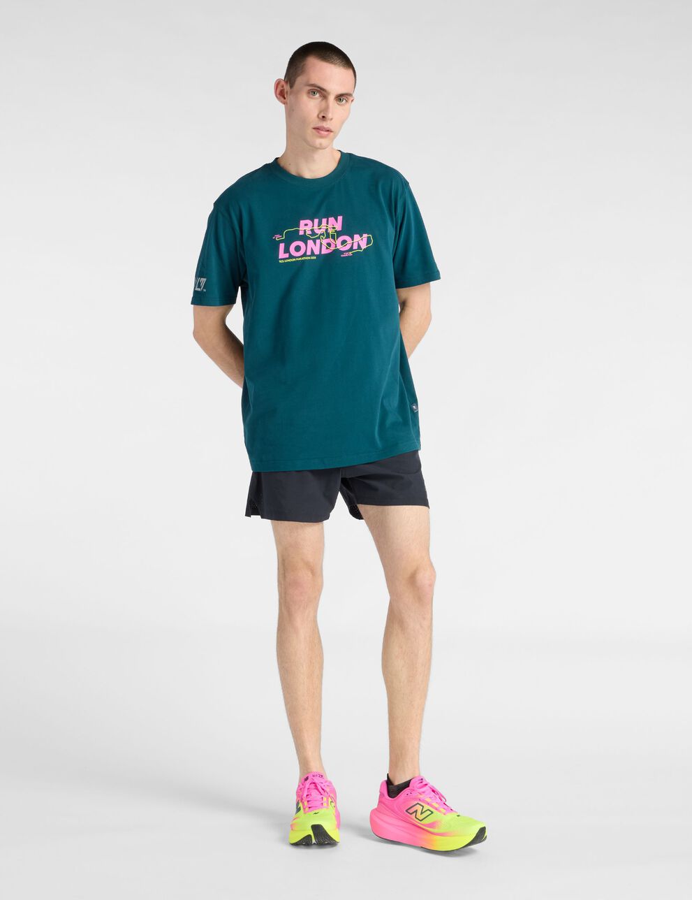 A person standing against a tan studio backdrop.