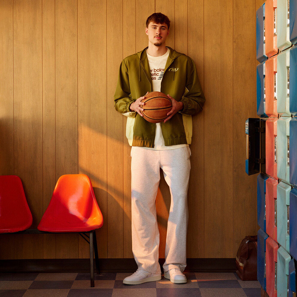 Endrick leaning against a wall wearing a green soccer uniform with his arms together 